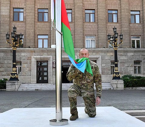 Azerbaijani President Ilham Aliyev kisses the National Flag in the city of Khankendi, Oct 15, 2023. (Photo | AP)