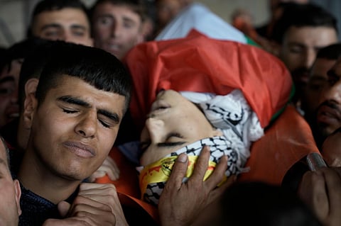 Palestinian mourners carry the body of Akram Dweikat, 17, killed in clashes with Israeli forces during his funeral in the West Bank city of Nablus, Sunday, October 15, 2023.
