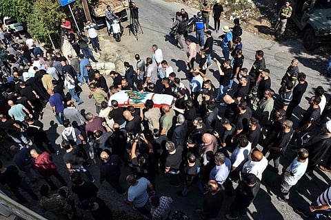 Mourners carry the flag-draped casket of Lebanese Reuters video journalist Issam Abdallah during his funeral in the village of El-Khiam on October 14, 2023. (Photo | AFP)
