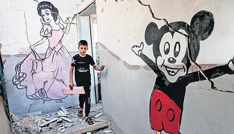 A Palestinian boy walks down the stairs of a destroyed building following an Israeli airstrike in Rafah in the southern Gaza Strip on Monday | AFP