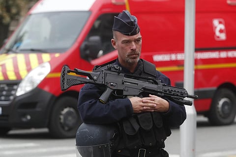 A police officer stands guard after a man armed with a knife killed a teacher and wounded two others in nothern France, Oct 13, 2023. (Photo | AP)