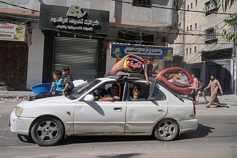 Palestinians fleeing from northern Gaza to the south with their belongings stacked on their cars after the Israeli army issued an unprecedented evacuation warning. (AP Photo)
