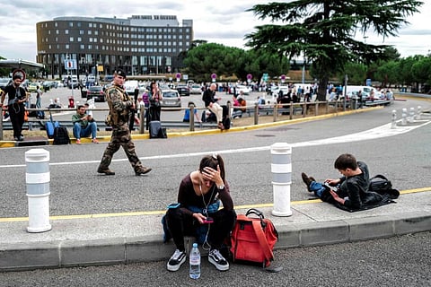 Passengers wait as a French soldier patrols outside the Toulouse-Blagnac Airport in Blagnac, southwestern France, on October 18, 2023. (Photo |AFP)