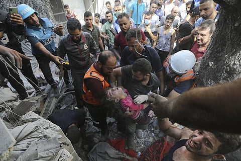 Palestinians rescue a child from under the rubble after Israeli airstrikes in Gaza City, Gaza Strip, Wednesday, Oct. 18, 2023. (Photo | AP)