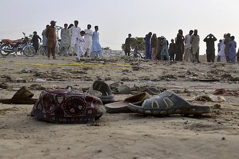 Local residents stand at the site of a suicide bombing in Mastung near Quetta, Pakistan on September 29, 2023. (Photo | AP)