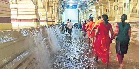 Devotees wade through a flooded corridor of the Ramanathaswamy temple following heavy rains in Rameswaram on Thursday. (Photo | Express)