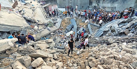Palestinians inspect the site where a Greek Orthodox church was destroyed following Israeli airstrikes on Gaza City on Friday | AP