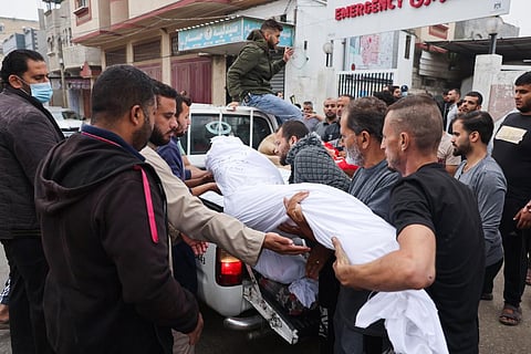 Palestinians transport bodies of relatives killed after Israeli strikes in Rafah in the southern Gaza Strip on October 23. (Photo | AFP)