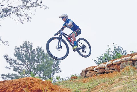 A cyclist practises gap jump (Downhill category) on Sunday ahead of the Asian Mountain Bike Cycling Championship-2023 at Ponmudi in Thiruvananthapuram from October 26 to 29 | B P Deepu