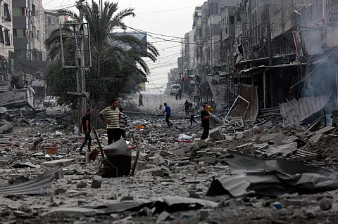 Palestinians inspect the damage of destroyed buildings following Israeli airstrikes on Gaza City, Friday, Oct. 27, 2023. (Photo | AP)