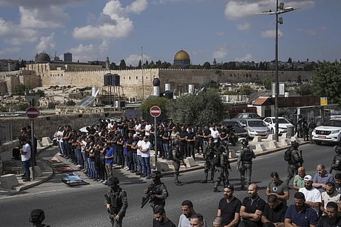Israeli border guards walk past Muslim worshippers during the weekly Friday prayers on the Mount of Olives in Israeli-annexed East Jerusalem on October 27, 2023. (Photo | AFP)