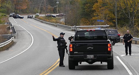 Police officers speak with a motorist at a roadblock. (Photo | AP)