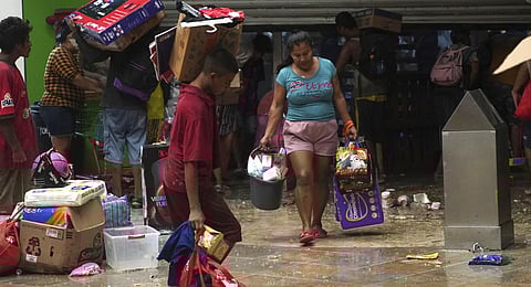 People carry away items they took from a grocery store after Hurricane Otis ripped through Acapulco, Mexico. (Photo | AP)
