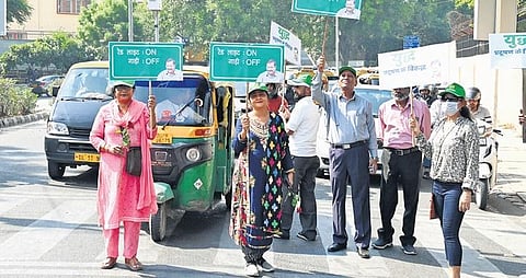 Volunteers hold placards at a traffic junction in ITO as part of the ‘Red light on, gaadi off’ campaign on Thursday | SHEKHAR YADAV