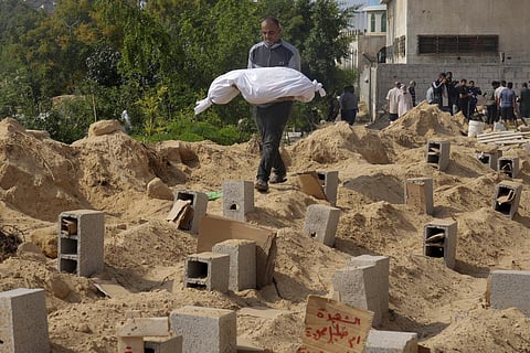 Palestinians bury the bodies of their relatives killed in the Israeli bombardment of the Gaza Strip, at a cemetery in Deir Al-Balah, Gaza. (Photo | AP)