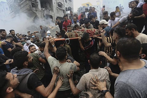 Palestinians remove a dead body from the rubble of a building after an Israeli airstrike Jebaliya refugee camp, Gaza Strip, Monday, Oct. 9, 2023. (Photo | AP)
