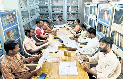 People are seen reading magazines and newspapers at a library.