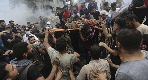 Palestinians remove a dead body from the rubble of a building after an Israeli airstrike Jebaliya refugee camp, Gaza Strip. (Photo | AP)