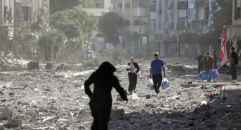 Palestinians leave their homes following Israeli bombardment on Gaza City. (Photo | AP)