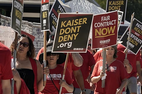 Kaiser Permanente mental health workers and supporters march outside a Kaiser facility in Sacramento. (Photo | AP)