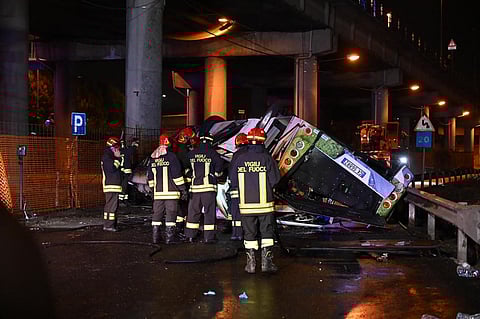 Firefighters work on the site of a bus accident on October 03, 2023 in Mestre, near Venice. The bus caught fire after careering off a bridge linking the Mestre and Marghera districts. (Photo | AFP)