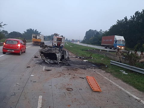 The mangled remains of the car which caught fire after colliding with a lorry on NICE Road in Bengaluru on Tuesday. (Photo | Express)
