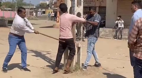 A Muslim man being beaten up allegedly by a policeman in Gujarat's Kheda district. (Video grab)