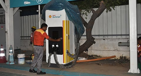 An employee operating an e-vehicle charging station in Chennai | Express