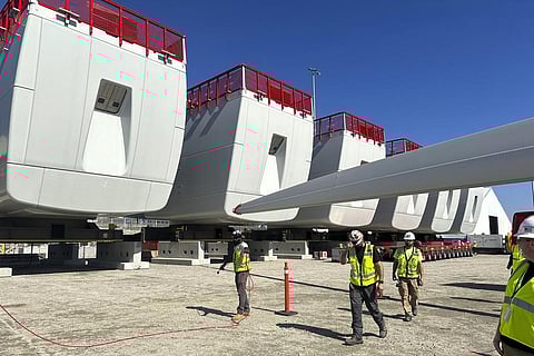 Workers walk by components of wind turbines at the State Pier in New London, Connecticut. The turbines will make up South Fork Wind Farm and eventually provide energy to New York. (Photo | AP)