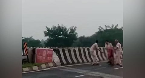 A screengrab from a video where three policemen, in Muzaffarpur, can be seen carrying a dead body, which they dumped into a canal.