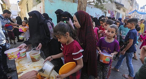 Palestinians receive food in Rafah, southern Gaza Strip. (Photo | AP)