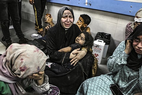 Wounded Palestinians sit in al-Shifa Hospital in Gaza City, after arriving from al-Ahli Hospital following an explosion there, Oct 17, 2023. (Photo | AP)