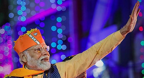 Prime Minister Narendra Modi waves at supporters during a roadshow ahead of the Madhya Pradesh Assembly elections, in Indore, Tuesday, Nov. 14, 2023. (PTI)