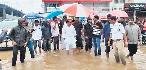 A file photo shows Minister A Indrakaran Reddy in a water-logged street in Nirmal