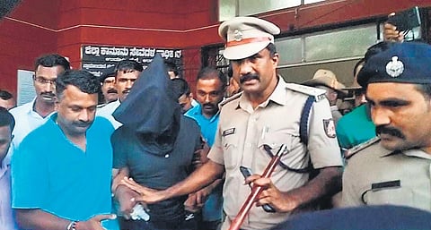 Police take accused Praveen Arun Chougule away, after his appearance in court, in Udupi on Wednesday | Express