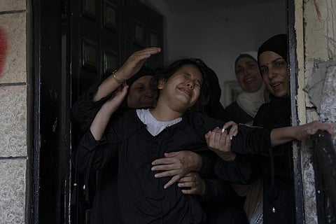 Palestinian mourners cry after taking one last look at the body of Mossab Ghoul, 21, during the funeral for seven killed Palestinians in the West Bank City, Nov 15, 2023. (Photo | AP)