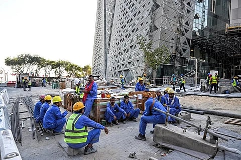 Migrant builders take a break while working at a construction site by the Corniche, in Doha, on November 24, 2022, during the Qatar 2022 World Cup football tournament. (File Photo | AFP)
