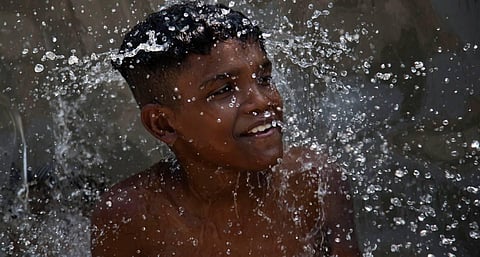 A youth cools off in a water fountain at Madureira Park amid a heat wave in Rio de Janeiro, Brazil. (AP photo)