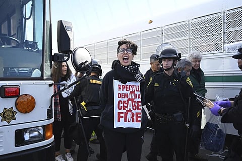 Police officer detain a protester blocking the San Francisco-Oakland Bay Bridge while demonstrating against the APEC summit and the Israel-Hamas war, Nov 16, 2023. (Photo | AP)
