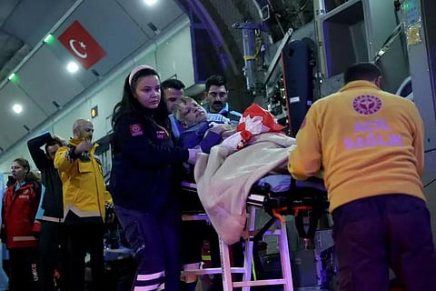 A Palestinian cancer patient, who had crossed from Gaza into Egypt, is carried on a stretcher after arriving at the Esenboga Airport in Ankara on November 16, 2023. (Photo | AFP)