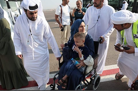 Palestinian mother carrying her child arrives in Abu Dhabi after being evacuated from Gaza as part of a humanitarian mission organised by the UAE. (Photo | AFP)