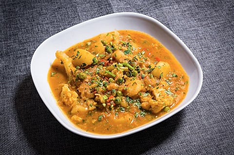 The Bengali variant of Aloo-Gobi cooked with minimal spices - just some kalonji, ginger and hing to be had with Luchi. (Photo | Flickr)