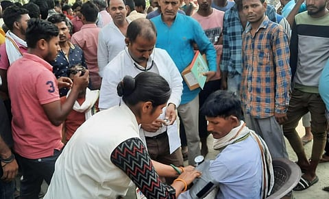 Representational Image: A nurse checks a man who allegedly consumed suspected spurious liquor, in Motihari in Bihar, on April 16, 2023. (Photo | PTI)