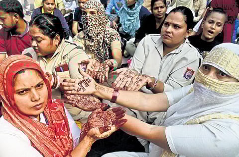 Civil Defence Marshals show henna designs during their protest demanding wages at Delhi Secretariat in New Delhi on Wednesday | Parveen Negi