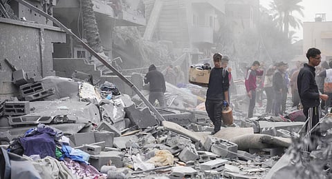 Palestinians look at destruction by the Israeli bombardment of the Gaza Strip, in Deir al Balah, Wednesday, Nov. 22, 2023. (Photo | AP)