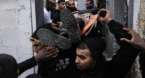 Palestinians carry a body away from the site of an Israeli strike after a military raid in the town of Tulkarem, West Bank, Wednesday, Nov. 22, 2023. (Photo | AP)