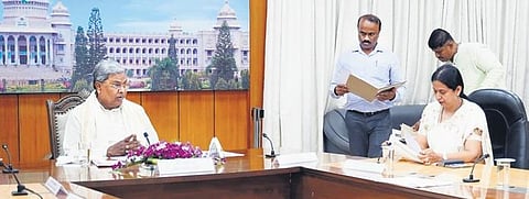 Chief Minister Siddaramaiah reviews the Gruha Lakhmi scheme in Bengaluru on Wednesday. Minister Laxmi Hebbalkar looks on. (Photo | Express)