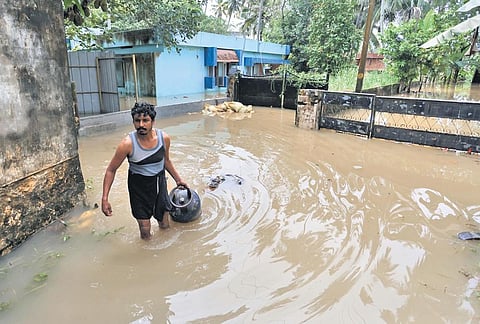 A man carrying a cylinder out of his flooded home at Kannammoola in Thiruvananthapuram on Thursday | B P Deepu