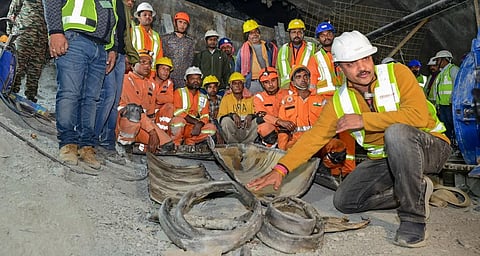 Workers show parts of an auger machine damaged during drilling inside the collapsed section of the Silkyara tunnel in Uttarkashi district on Friday. (Photo | PTI)
