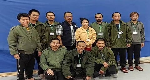 AÂ Thai official (center) posing for a group photo with 10 released Thai hostages in Israel, after they were freed by Hamas. (Photo | AFP)